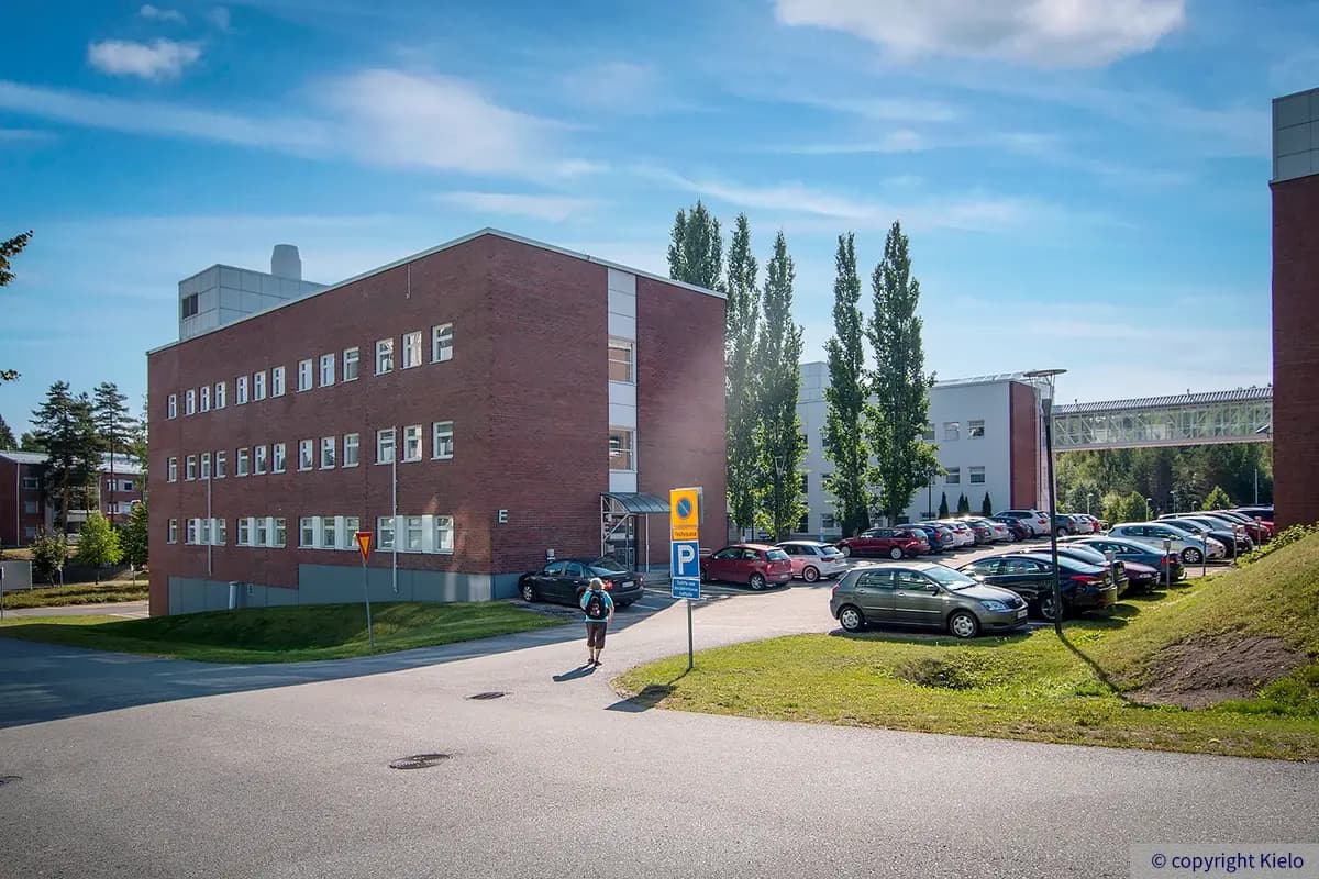 Toimilakiinteistö Lappeenrannan Laserkatu 6, rakennus E. U:n muotoinen toimistotalo, joka kadunpuoleinen julkisivu on punatiiltä. Sisäpihanpuoli valkoinen. Talon edessä pysäköintialue.