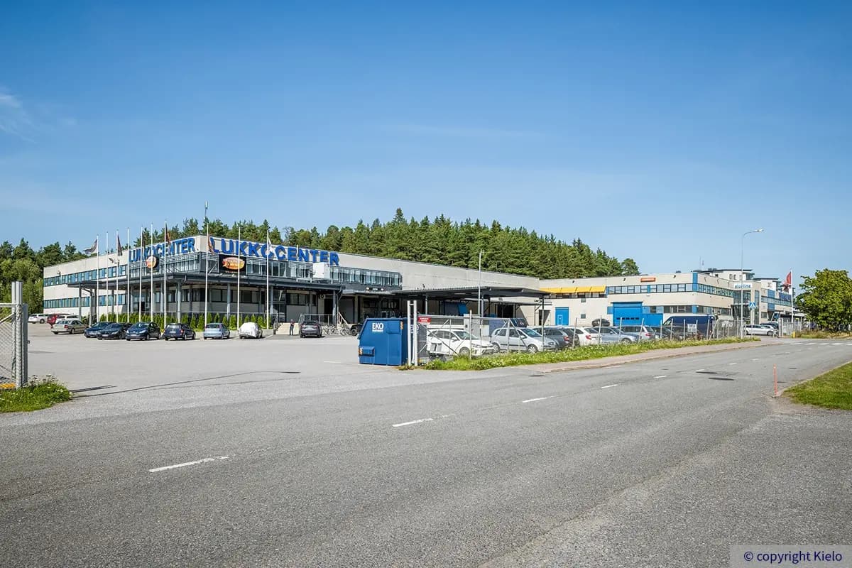 Lukkocenter julkisivu. Kaksikerroksisen kiiteistön päädyssä kyltti ja tietokonejälleenmyyjä.