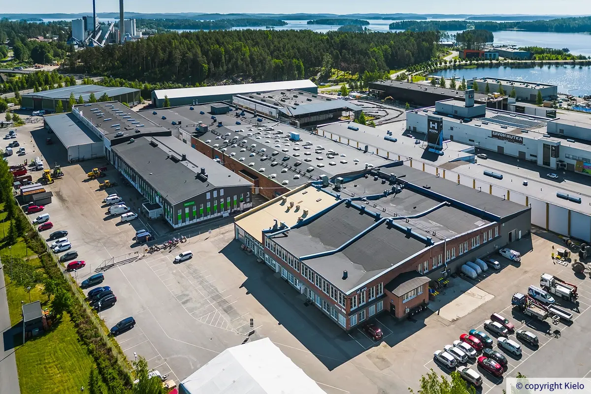 Ilmakuva Kuopion Varikkokatu 2 -kiinteistöstä. Etummaisena punatiilinen rakennusosa, jonka edessä pysäköintialue.