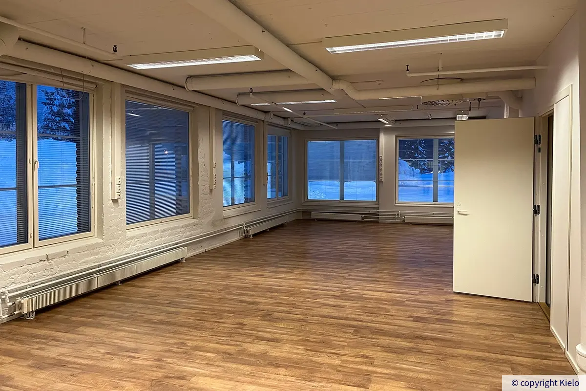 Kuopion Varikkokatu 2 avoin 109,5 m2 toimistotila. Isossa huoneessa on suuret ikkunat kahdella seinällä.