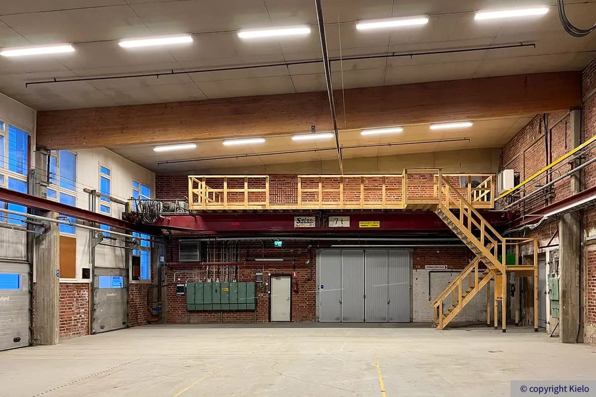 Kuopion Varikkokatu 2 korkea 827 m2 varastohalli, jossa paljaat tiiliseinät ja nosto-ovet.