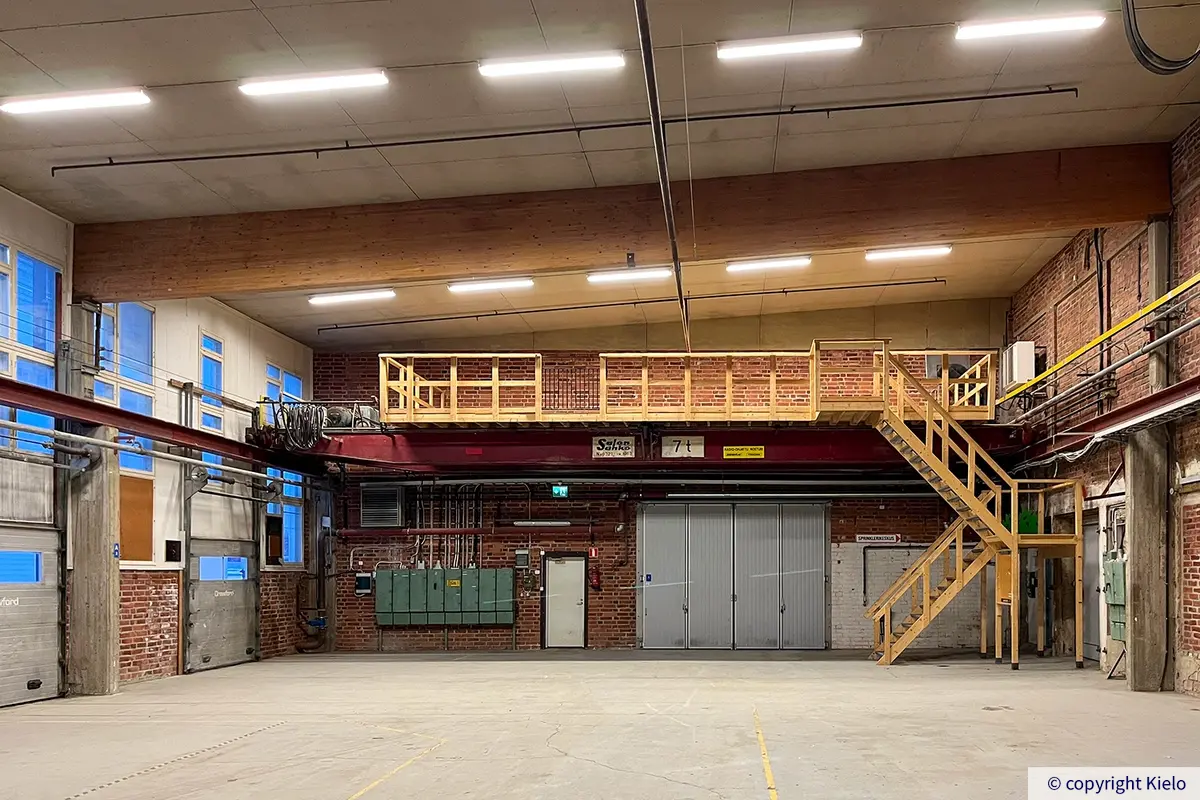 Kuopion Varikkokatu 2 korkea 827 m2 varastohalli, jossa paljaat tiiliseinät ja nosto-ovet.