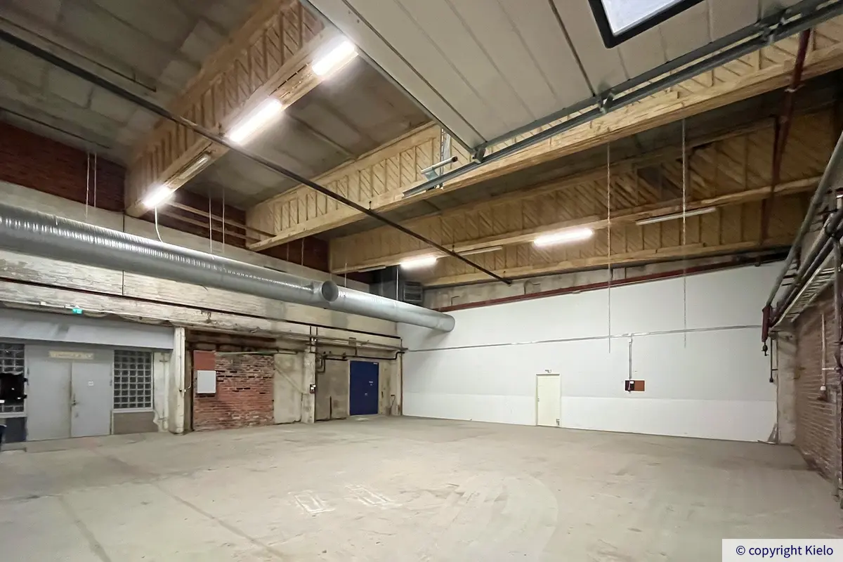 Kuopion Varikkokatu 2 katutason 827 m2 varastotila. Paljaspintaisessa hallissa on korkea katto.