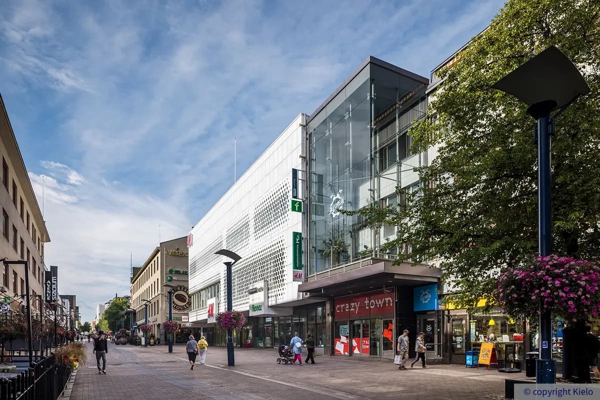 Jyväskylän Kauppakatu 37 vilkkaan kävelykadun varrella. Selkeälinjainen valkoinen julkisivu erottuu kadun muusta rakennuskannasta.