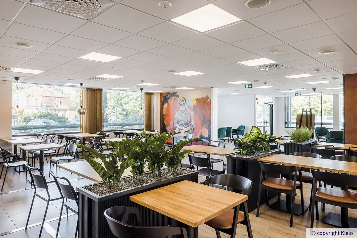 36Hatanpää ravontolan sali. Isoista ikkunoista tulvii valoa, ja yhdellä seinällä näyttävä seinämaalaus.