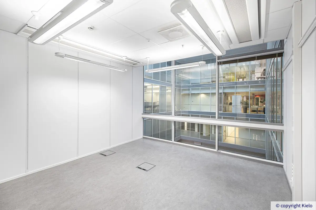 Jyväskylän Mattilanniemi 6-8 417 m2 toimitilan toimistohuone, jossa suuret ikkunat atriumille.