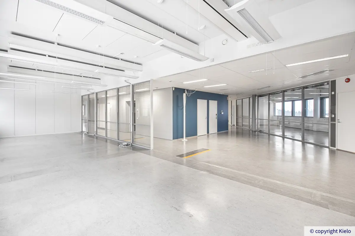 Jyväskylän Ohjelmakaari 10 viidennen kerroksen 695 m2 toimitilan kulman avotila, josta lähtee käytävät eri kulmissa.