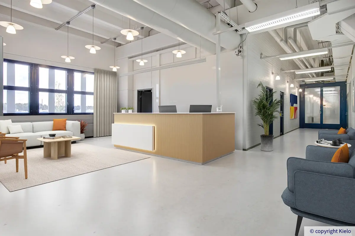 Helsingin Laippatie 1 kolmannen kerroksen digiremontoitu toimiston aulatila, jossa vastaanottotiski, sohvaryhmä ja nojatuolit.
