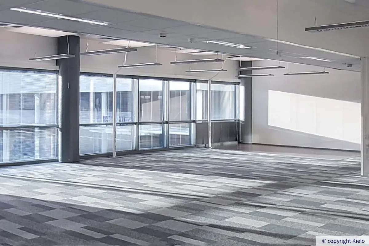 Jyväskylän Ohjelmakaari 10 toisen kerroksen 228 m2 toimitilan valoisa avotoimisto, jossa on suuret ikkunat ja kokolattiamatto.