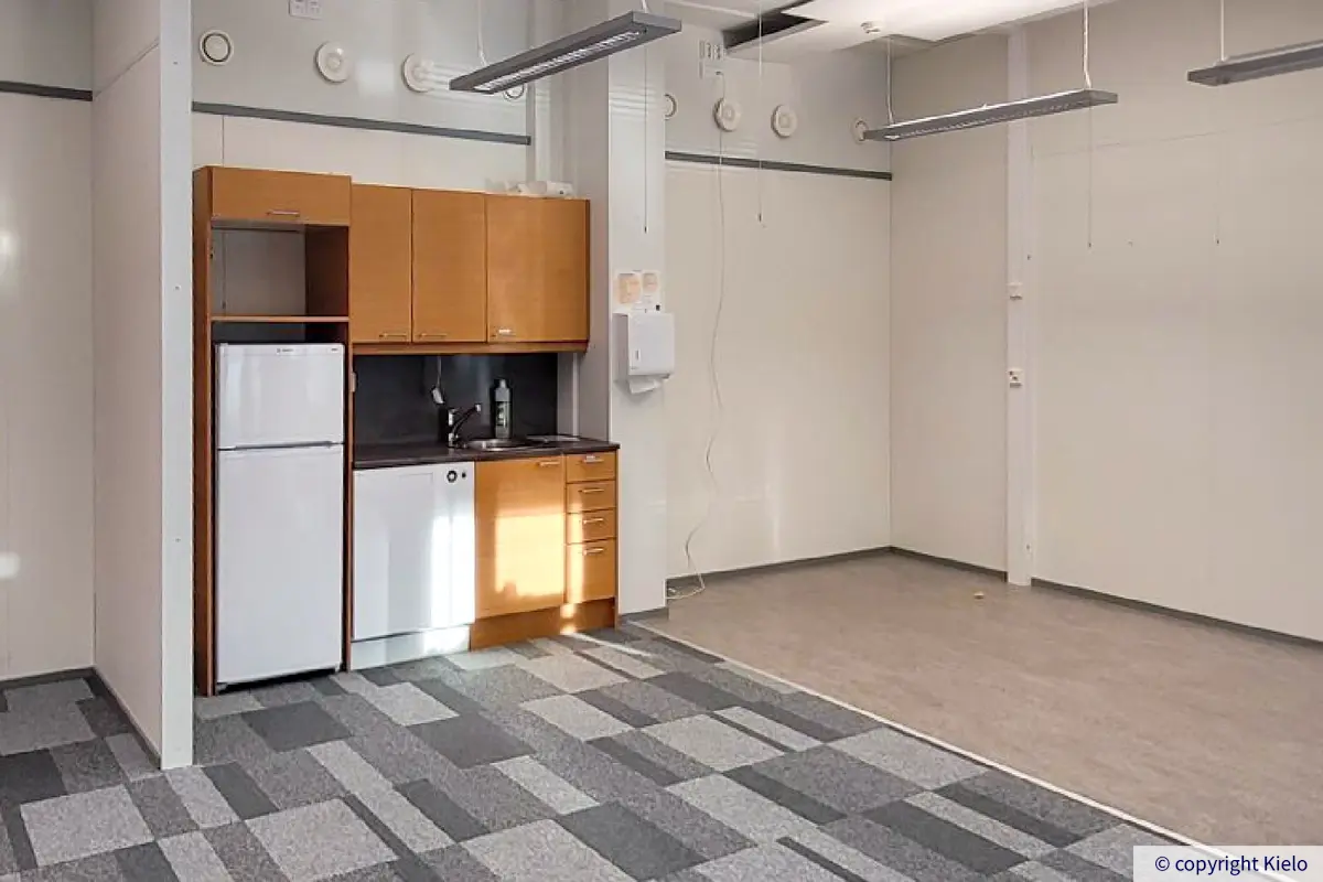 Jyväskylän Ohjelmakaari 10 toisen kerroksen 228 m2 toimitilan keittiökalusteet avotoimiston seinustalla.