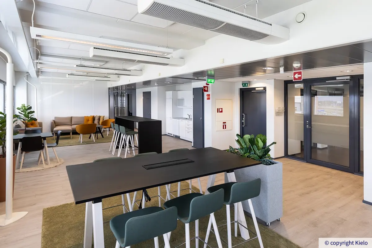 Gate8 Business Park referenssitilan avotilaa, jossa pöytäryhmä, keittiö ja sohvat.