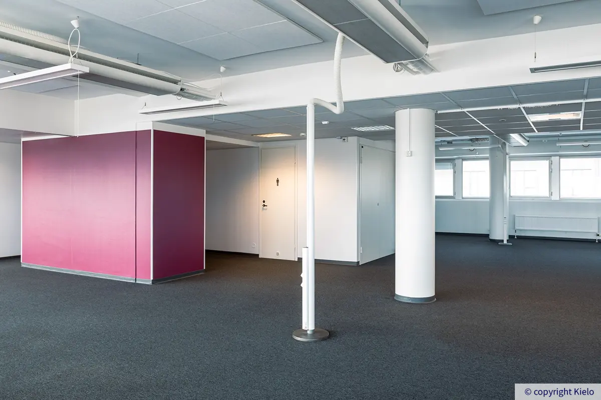 Jyväskylän Vapaudenkatu 48-50 avotoimiston pääty, jossa ovet vessoihin viininpunaisen seinän takana.