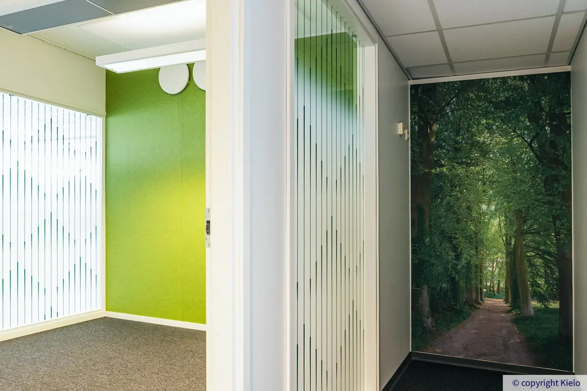 Jyväskylän Vapaudenkatu 48-50 toimistotilan vihreäseinäinen huone, viereisen käytävän päädyssä metsäprintti.
