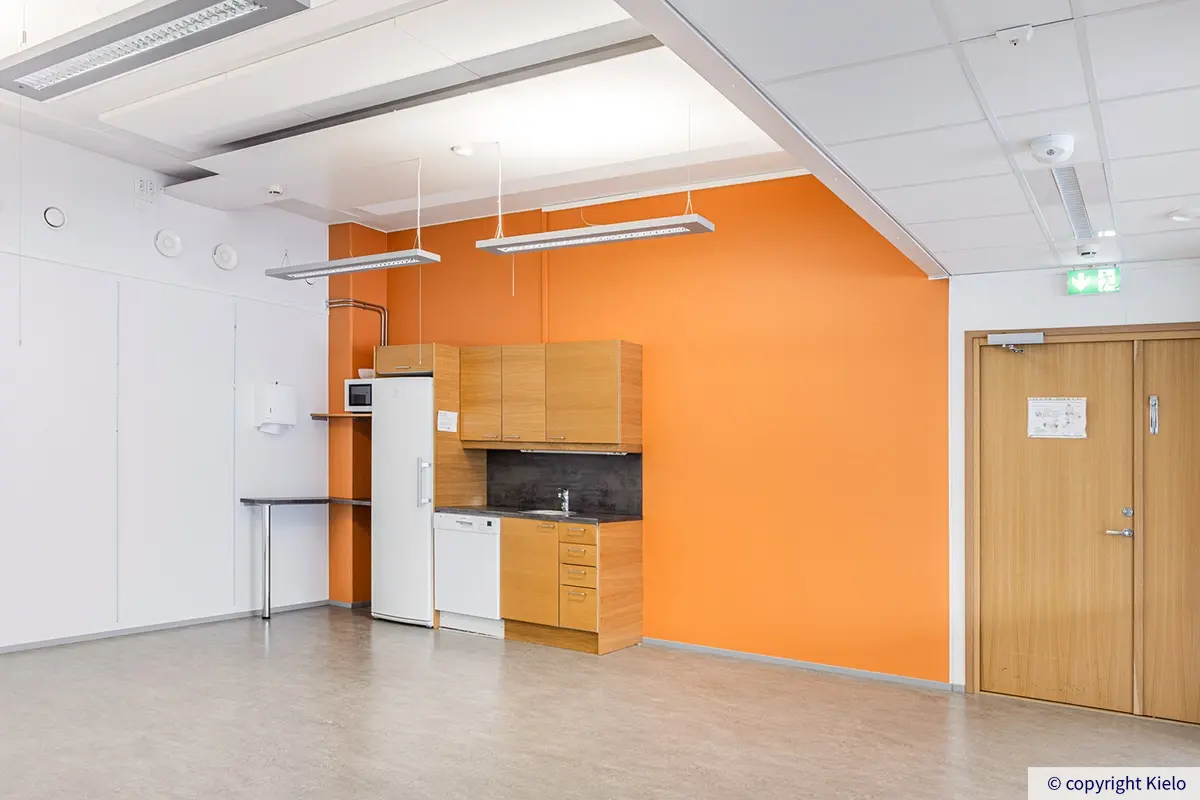 Jyväskylän Ohjelmakaari 2 220 m² toimitilan pienkeittiö oranssilla seinällä.