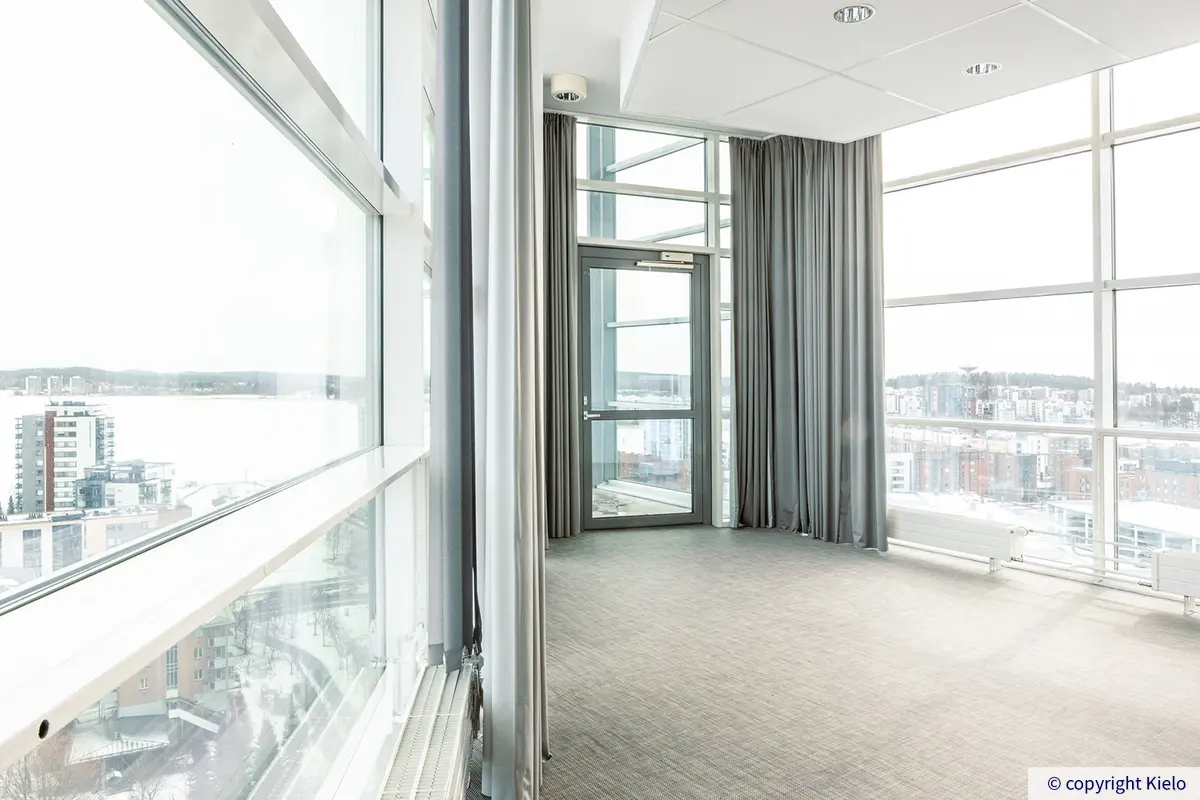 Innova 1 14. kerroksen toimistotilan neuvotteluhuone, jossa näkymät kauas korkeista, lattiasta kattoon yltävistä ikkunoista.