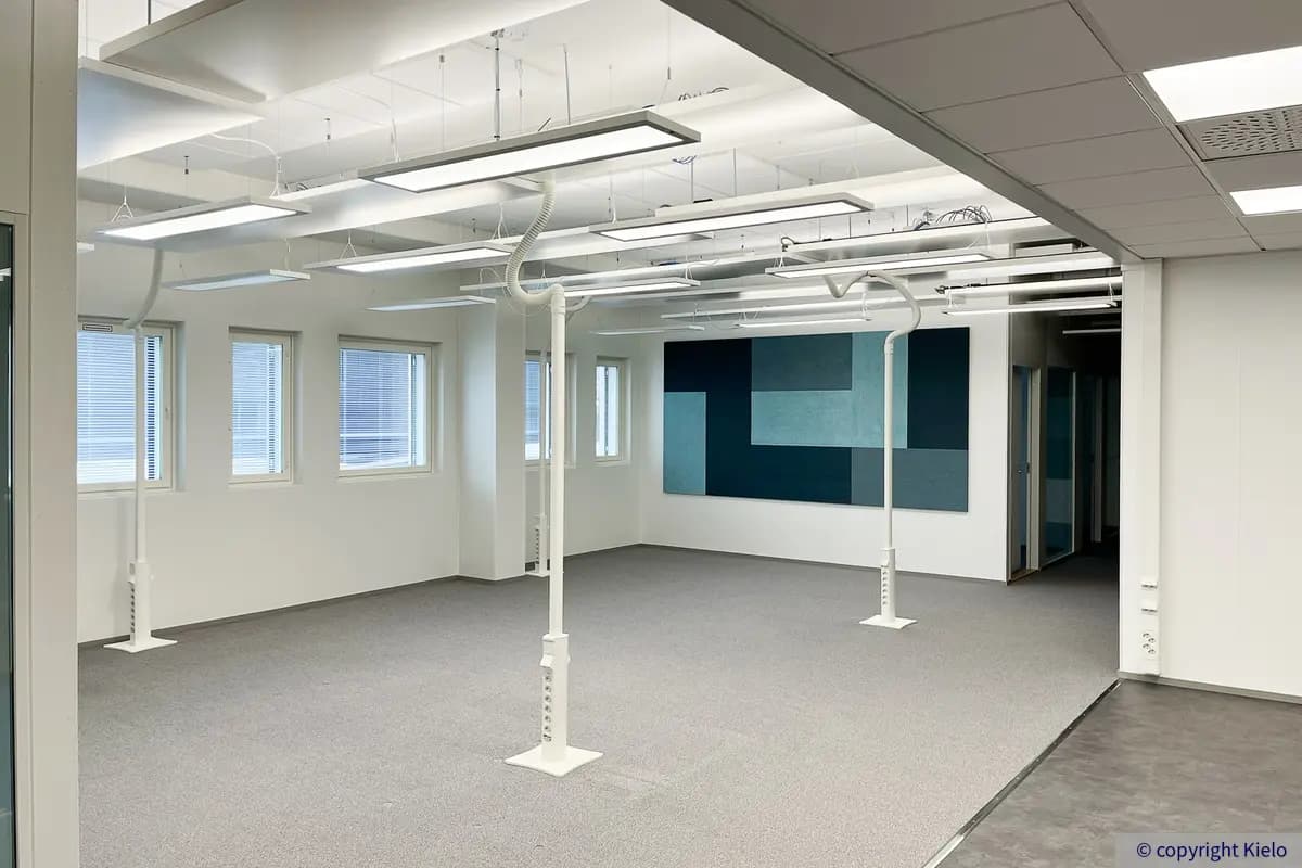 Kuopion Portti C1 toimitilakiinteistönn 2. kerroksen 235 m2 toimitilan avotila, jossa harmaa lattia ja vaaleat pinnat.