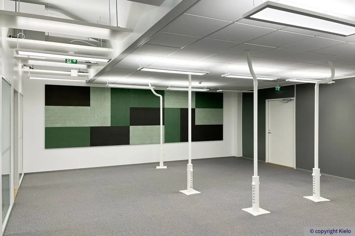 2. kerroksen 235 m2 toimitilan avotila, jossa harmaa lattia. Seinällä iso monivärinen taulu.