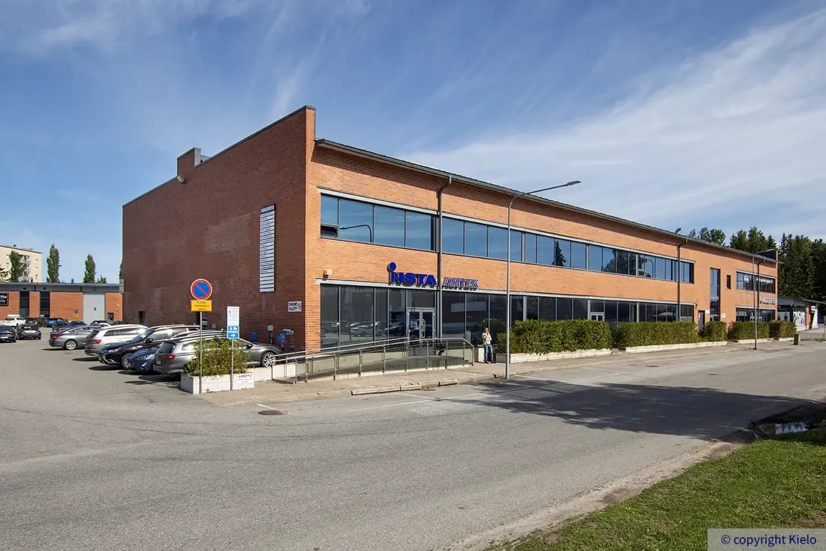Punatiilinen toimisto- ja liiketilasiipi Purocenter-kiinteistössä. Päädyssä listattu kohteessa toimivia yrityksiä.