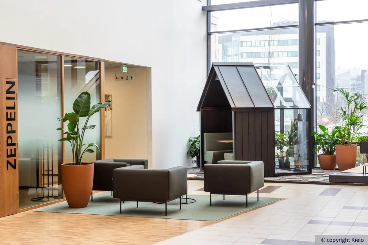 Gate8 Business Park Largo toimitilakiinteistön aula, jossa vuokrattava neuvottelutila ja nojatuoleja ringissä.