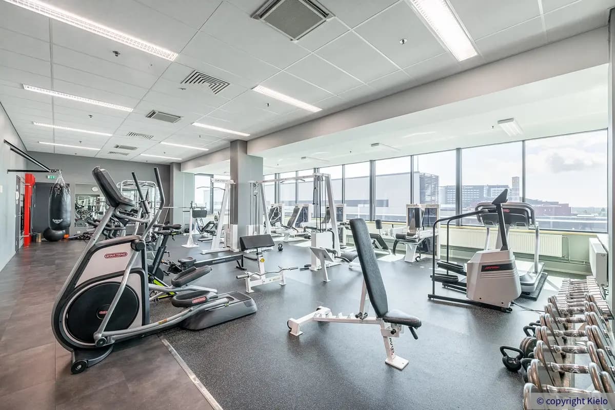 Gate8 Business Park Largo toimitilakiinteistön valoisa kuntosali, jossa laajavalikoima kuntosalilaitteita ja isot ikkunat.