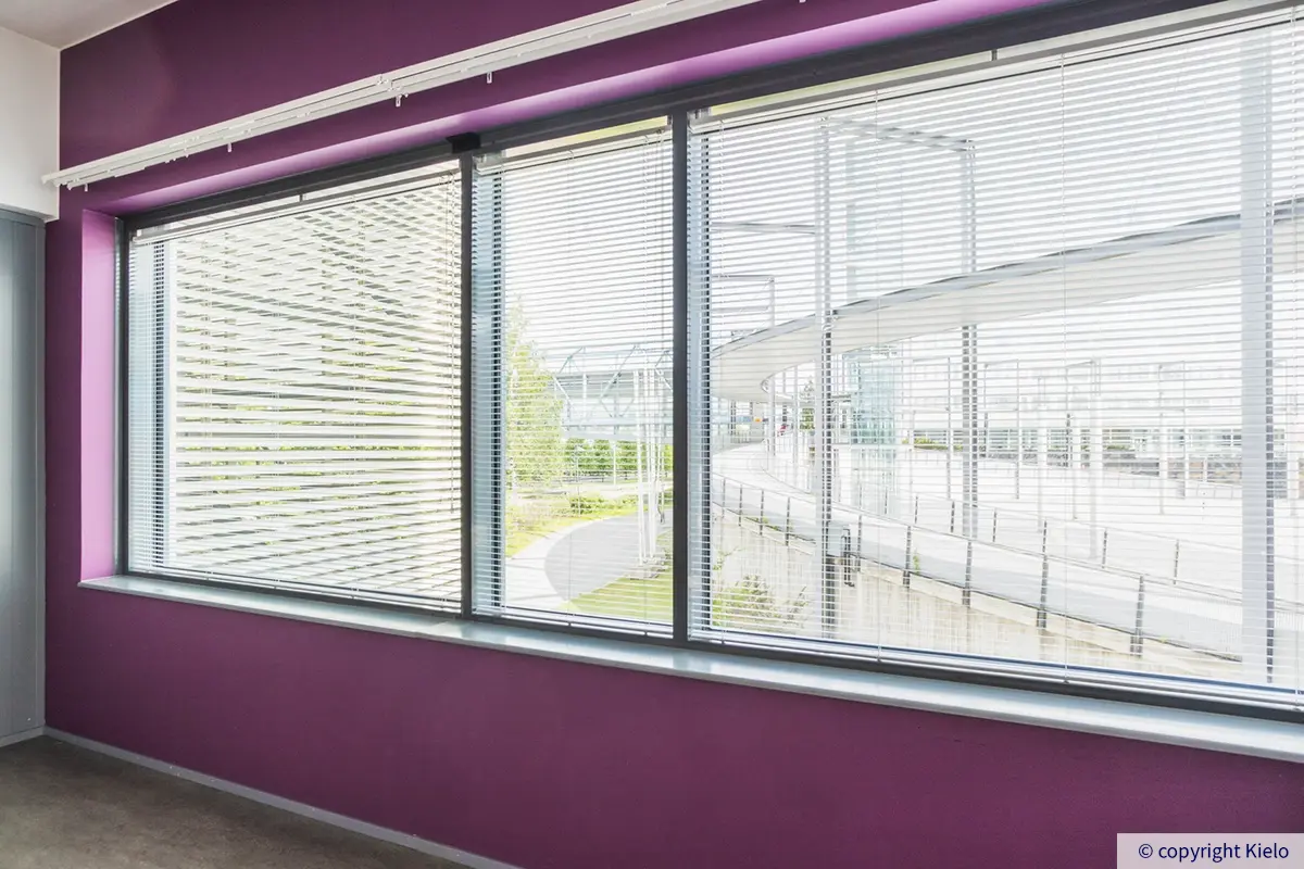 Innova 2 toimitilakiinteistön 569 m2 toimitilan erillinen valoisa työhuone, jossa isot ikkunat ja värikäs tehosteseinä.