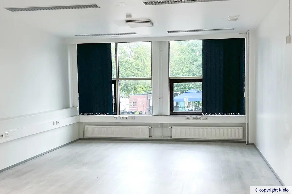 Pohjoislaakso toimitilakiinteistön 1. kerroksessa sijaitseva siisti 48,5 m2 kokoinen avotoimisto, jossa isojen ikkunoiden edessä tummat pimennysverhot.