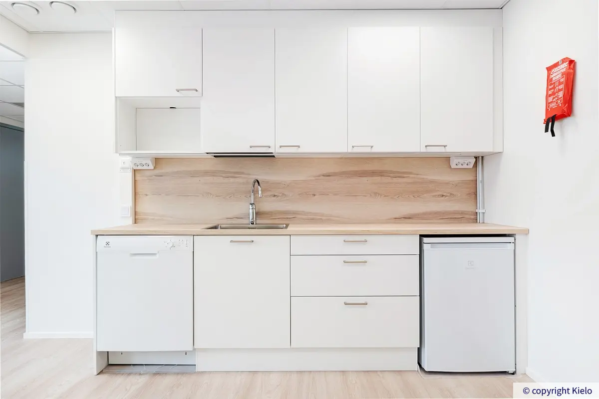 Kauppakaari 15 kiinteistön 2. kerroksessa sijaitsevan 284 m2 toimitilan uusi keittiö, jossa valkoiset kalusteet ja kodinkoneet.