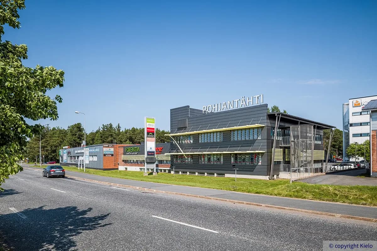 Oulun Voudintie 4 julkisivu, jossa kohteessa toimivien yritysten logoja valomainoksissa