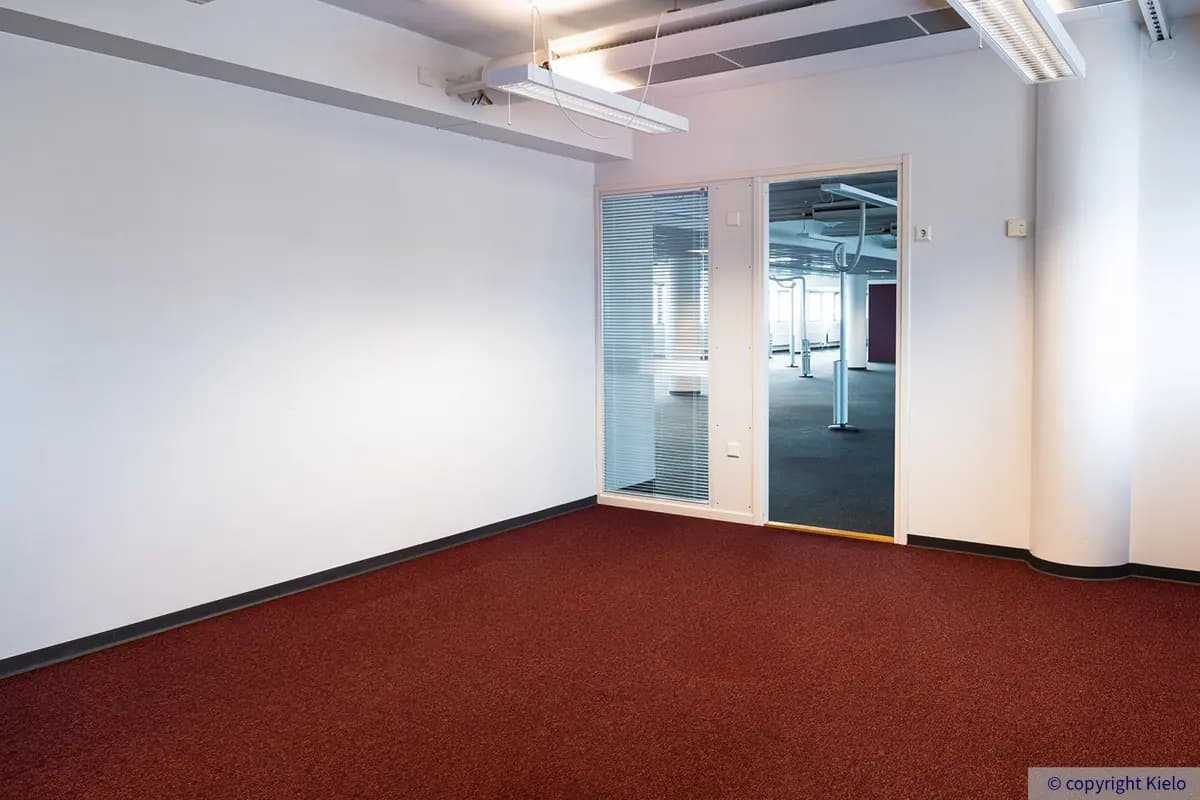 Jyväskylän Vapaudenkatu 48-50 sijaitsevan toimitila, jossa tummanpunainen kokolattiamatto.