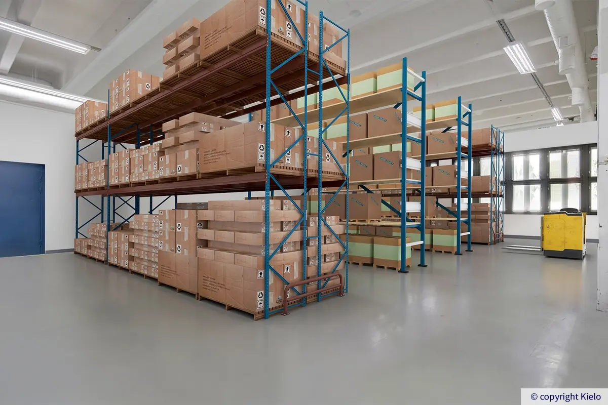 Helsingin Laippatie 1 virtuaalikalustettu korkea varastotila toisessa kerroksessa. Toimitilassa on varastohyllyt, joissa runsaasti lavoja.