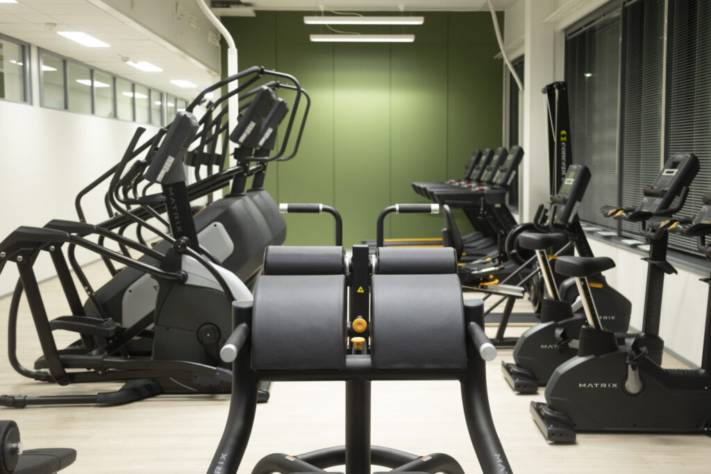viihtyisä kuntosali täynnä erilaisia kuntoilulaitteita
