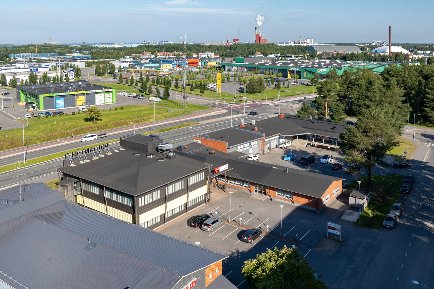 Oulun Voudintie 4 mustakattoinen kiinteistön ilmakuvassa. Kiinteistön pihalla pysäköintialue.