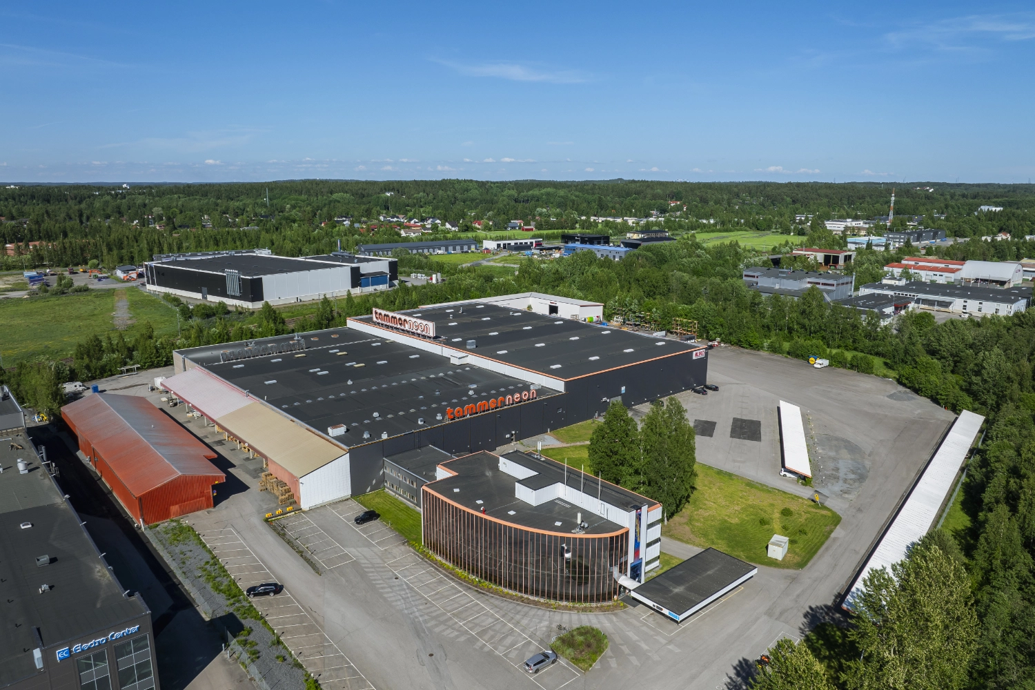 Tampereen Yrittäjänkulma 5 ilmakuvassa. Kiinteistössä on suuri teollisuushalli, lasijulkisivuinen toimistosiipi ja pihassa ulkovarastoa.