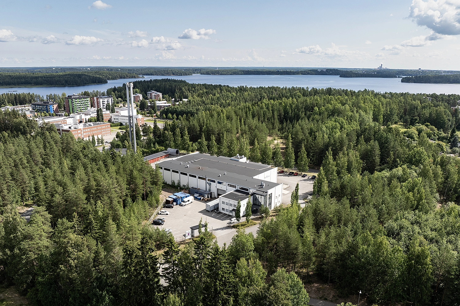 Kielo Lappeenranta – Tuotantokatu 2 toimitilakiinteistö puiden keskellä, takana järvimaisema