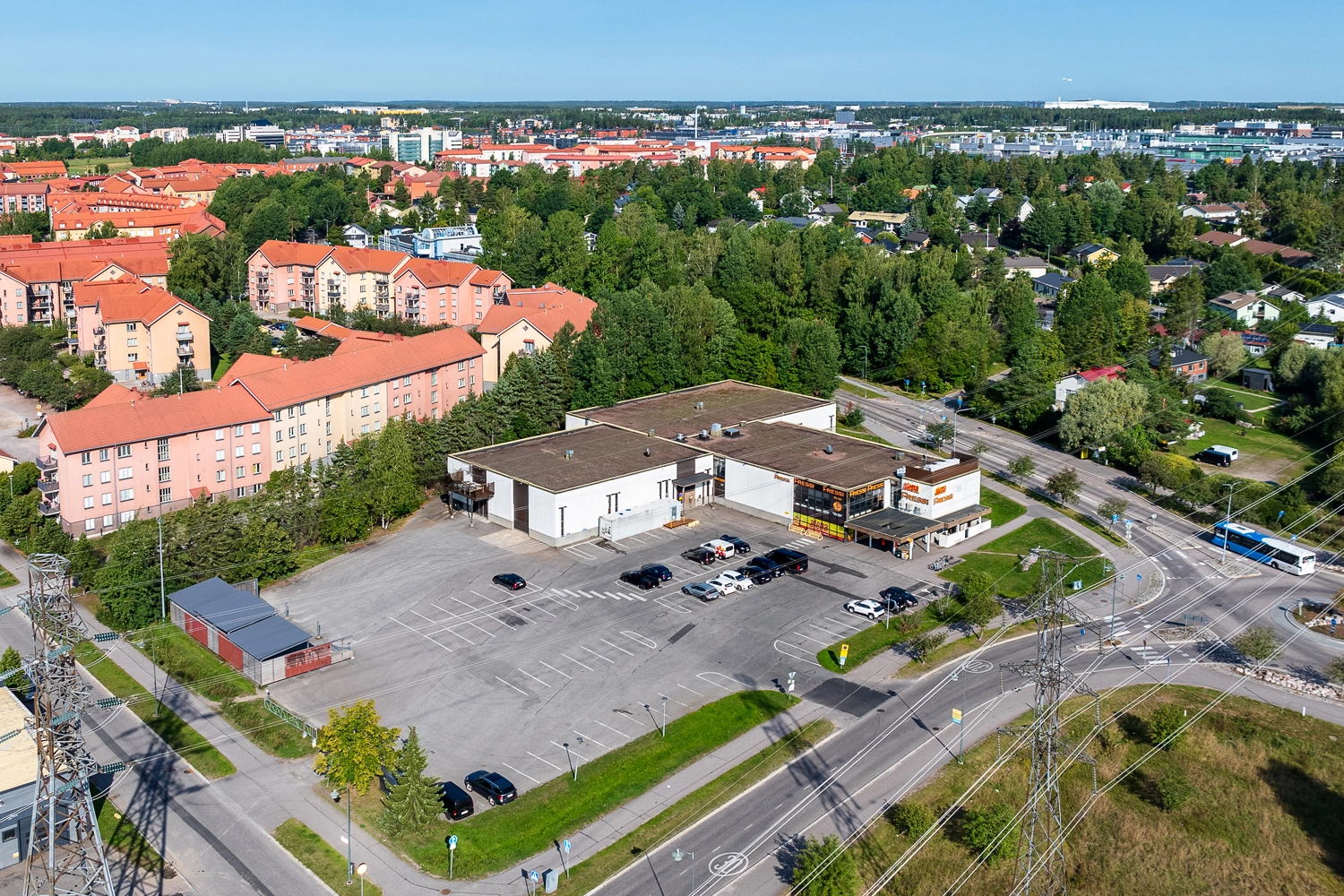 ilmakuvassa toimitilakiinteistö Vantaan Hagelstamintie 32, joka on T:n muotoinen yksikerroksinen rakennus. Talon edessä on pysäköintialue.