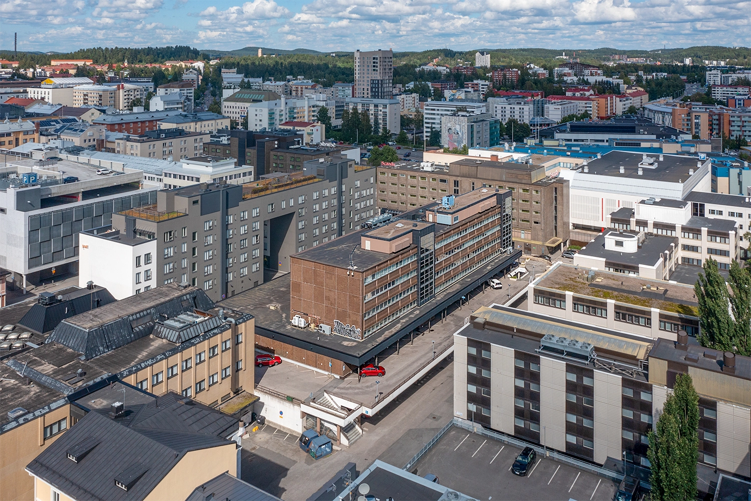 Jyväskylän Vapaudenkatu 48-50 kuvattuna ilmasta. Ruskea toimistota, joka on asuin- ja toimitilakiinteistöjen ympäröimä. 