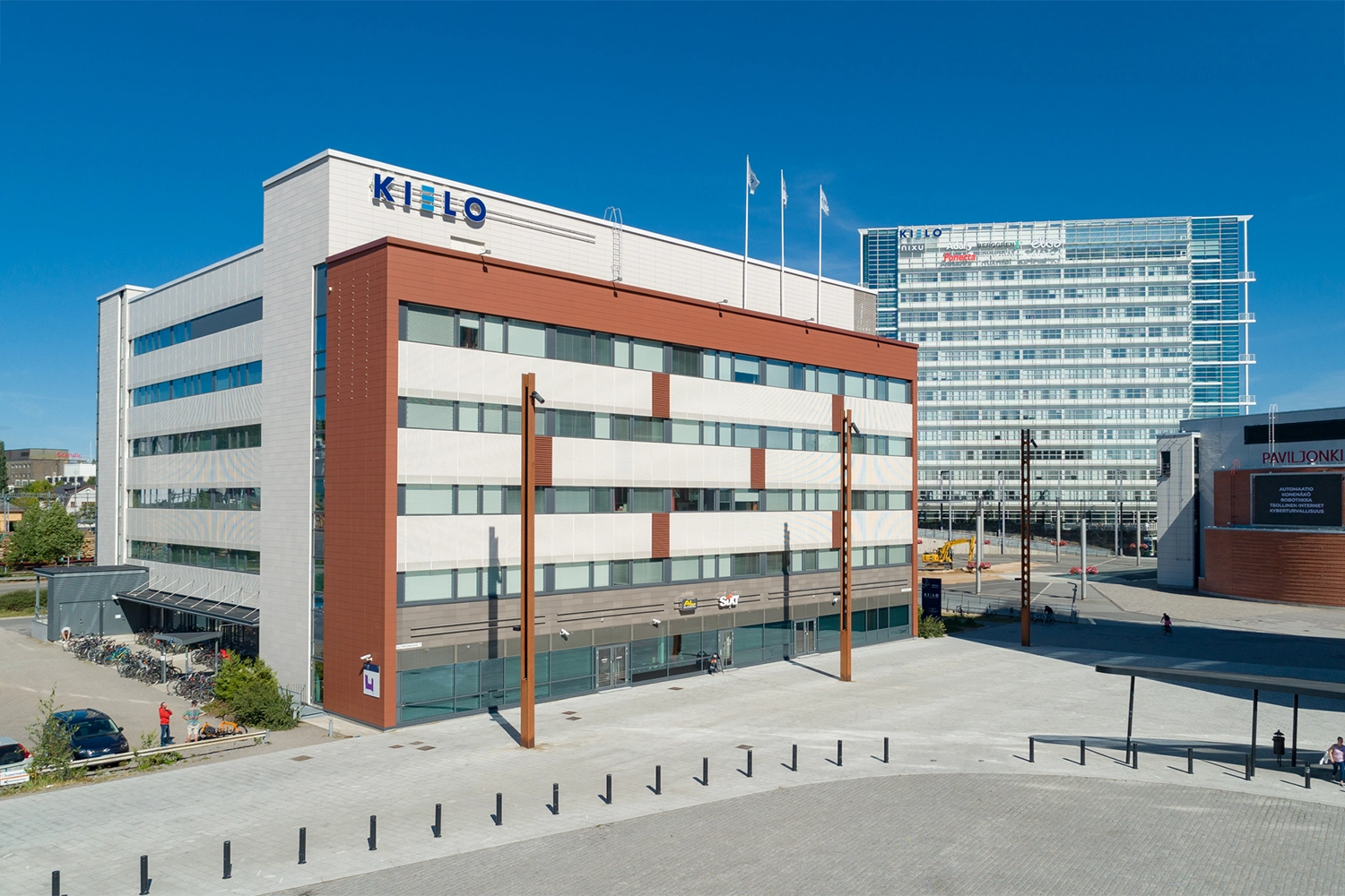 Innova 2 toimitilakiinteistön julkisivu. Kuusikerroksisen rakennuksen katolla lukee Kielo. 